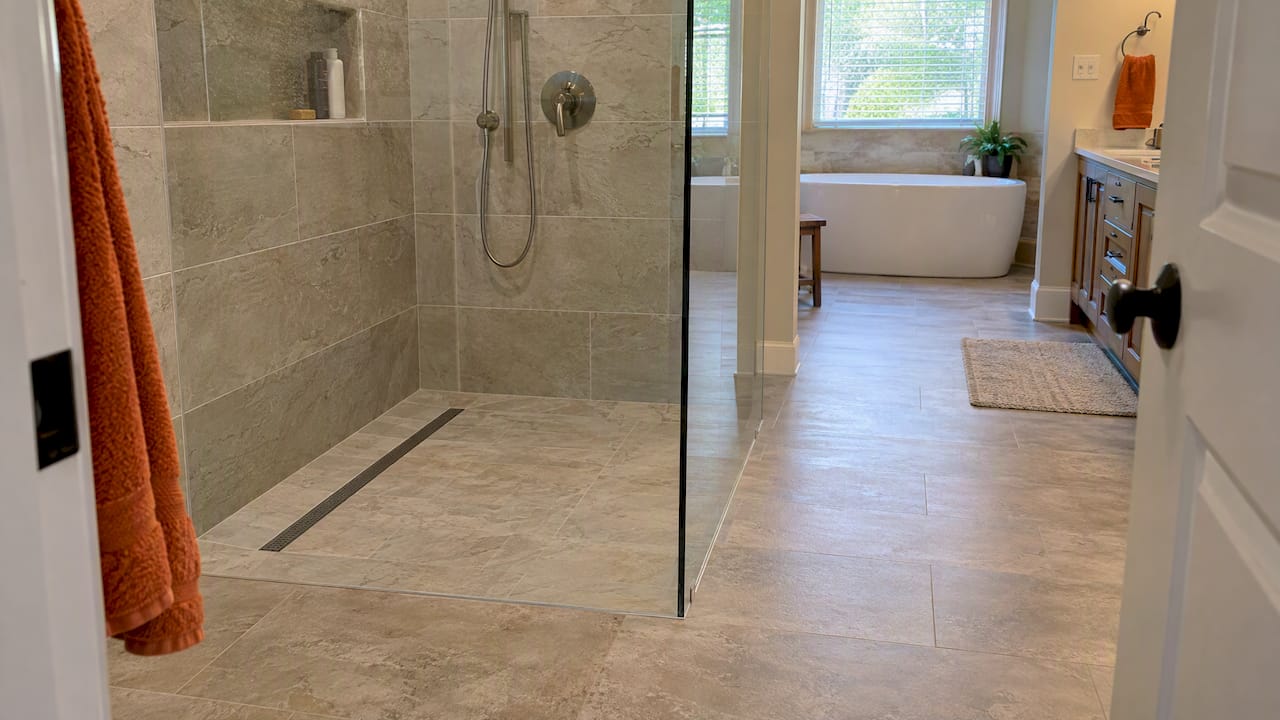 Finished curbless shower with flush bathroom floor